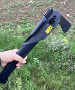 A mans hand holding a hatchet survival multi tool, against a grass and earth background.