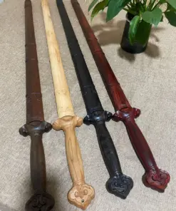 Four wooden Jian swords of differing color and wood material, displayed lying side-by-side on a carpet floor.
