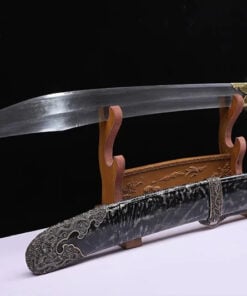 A Chinese broad sword displayed on a wooden sword-stand, with its decorative scabbard below on the floor.