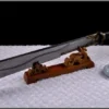 A Chinese cleaver sword displayed on a small, wooden sword-stand.