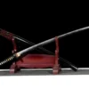 A Katana custom Wootz steel sword, displayed next to its scabbard, leaning against a small wooden stand.