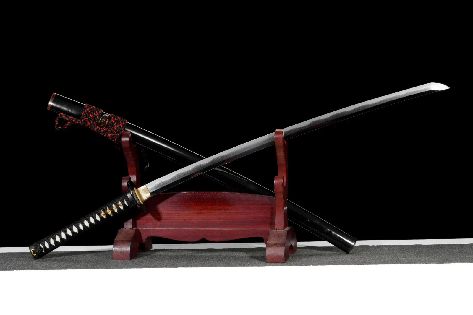 Katana Custom A Katana custom Wootz steel sword, displayed next to its scabbard, leaning against a small wooden stand.