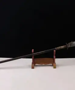 A Kwan Dao weapon displayed on a small wooden stand.