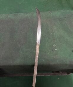 A naginata blade blank displayed against a green floor.