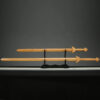 Two wooden Chinese swords of differing size, displayed on a small wood stand.