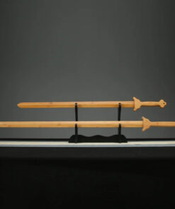 Two wooden Chinese swords of differing size, displayed on a small wood stand.
