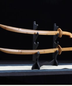 Two Chinese wooden saber swords of differing design, displayed on a small wooden sword-stand.