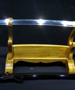 A one handed Japanese sword Wakizashi, displayed on a wooden sword-stand, with its black scabbard below on the floor.