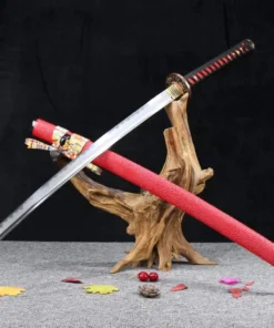 A custom Katana sword displayed crossed over its red scabbard, leaning against a small wood log.