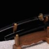 A custom Wakizashi sword, displayed next to its black scabbard on a small wooden sword-stand.