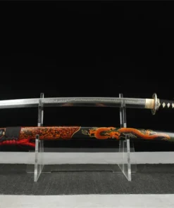 A red dragon Katana sword displayed next to its decorative scabbard, on a small plastic sword-stand.