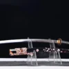 A sword flower Katana displayed next to its decorative scabbard, on a small plastic sword-stand.
