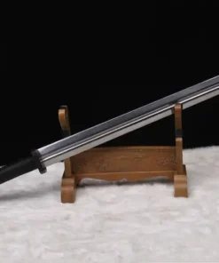 A big sword displayed leaning against a small wooden sword-stand.