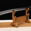 A Chinese Dao broadsword, displayed on a small wooden stand.