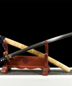 A decorated eagle sword Katana, displayed next to its engraved scabbard, leaming against a small wooden stand.