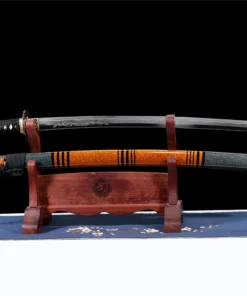 A dragon engraved sword Katana, displayed next to its scabbard, on a small wooden stand.