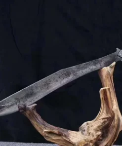 A full tang Kukri sword weapon, displayed balanced on a wood log branch.