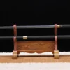 A walking cane with sword, displayed on a small wooden stand next to its stick-scabbard.