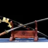 A wootz steel sword displayed next to its Koi-fish illustrated scabbard, leaning against a small wooden stand.