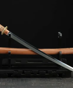 A WW2 Japanese sword Katana, displayed crossed against its scabbard, on a small wooden sword-stand.