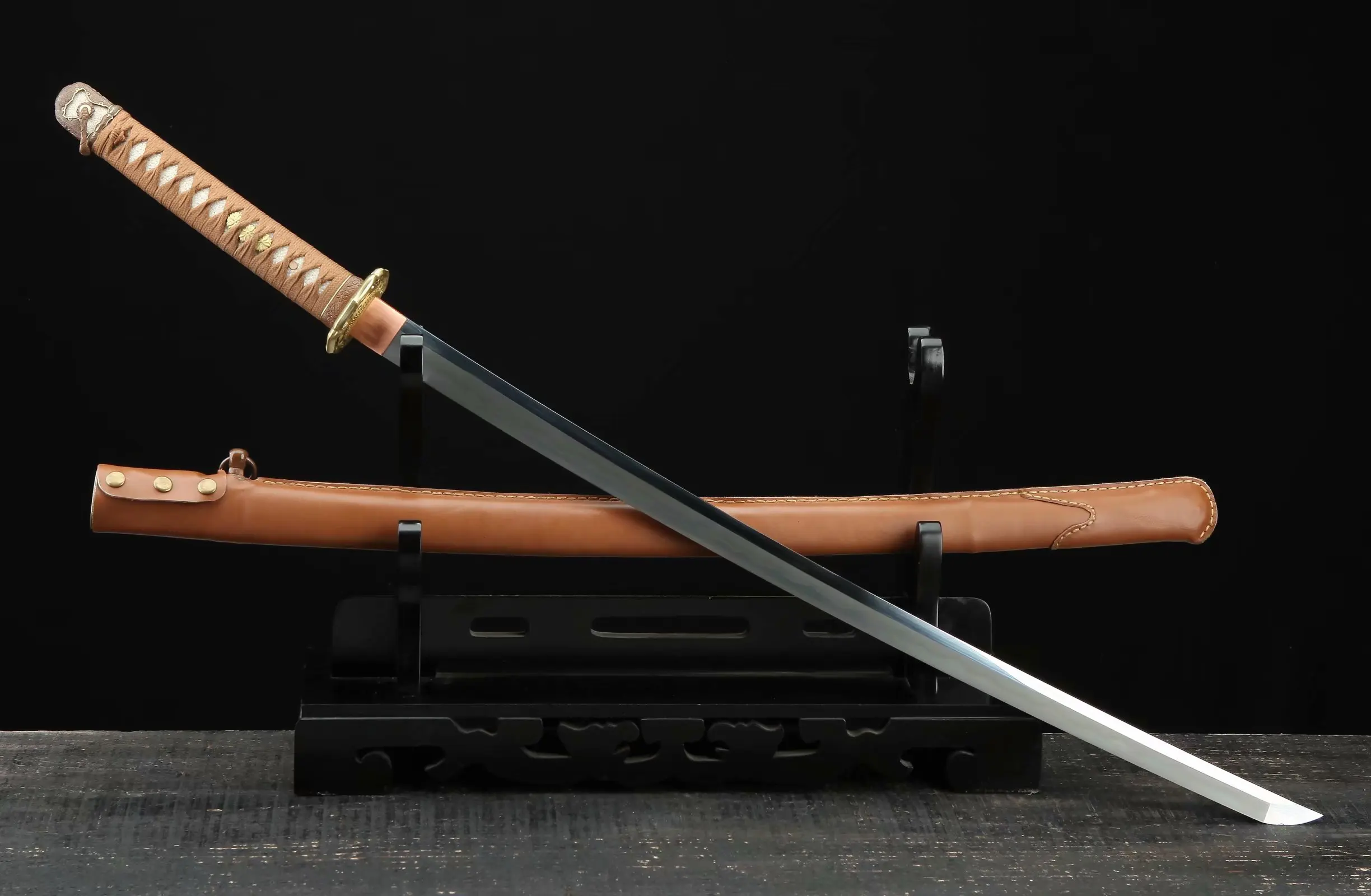 WW2 Japanese Sword A WW2 Japanese sword Katana, displayed crossed against its scabbard, on a small wooden sword-stand.