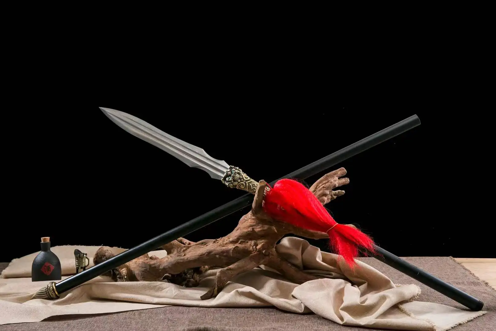 Chinese Spear A Qiang Chinese spear weapon displayed next to its handle-extension, leaning against a small wood log.