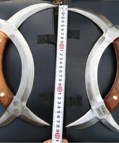 A pair of Chinese deer horn knives, displayed with measuring tape in-between the two knives.