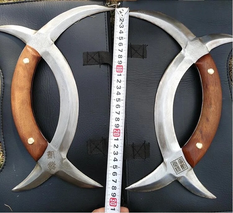 Deer Horn Knives A pair of Chinese deer horn knives, displayed with measuring tape in-between the two knives.
