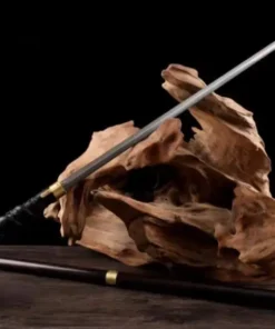 A dragon cane sword displayed leaning against a small wood log, with its stick scabbard below on the floor.