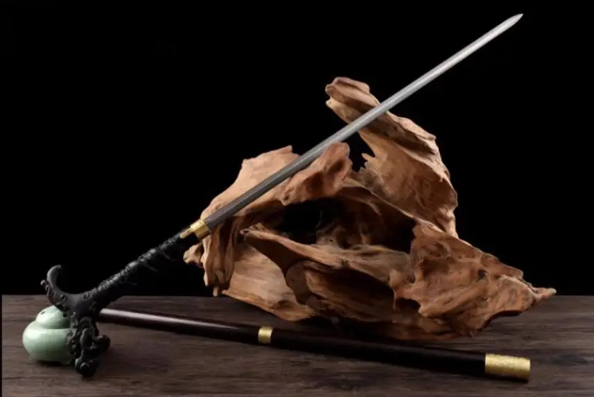 Dragon Cane Sword A dragon cane sword displayed leaning against a small wood log, with its stick scabbard below on the floor.