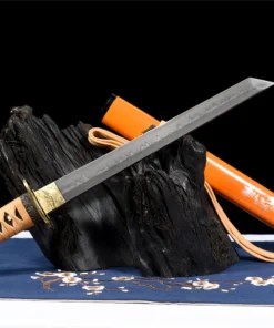 A Japanese Tanto sword and its scabbard, displayed leaning against a small wood log.