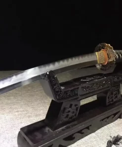 A Japanese Tanto weapon displayed on a small wooden stand.