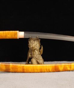 A Wootz steel knife Tanto, displayed on a small statue-stand, with its sheath below on the floor.