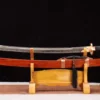 A Chinese Yaodao sword, displayed next to its scabbard, on a small wooden stand.