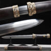 A Chinese traditional dagger knife, displayed on a wooden stand, with its sheath below on the floor, and close-ups of the knife's blade and hilt above.