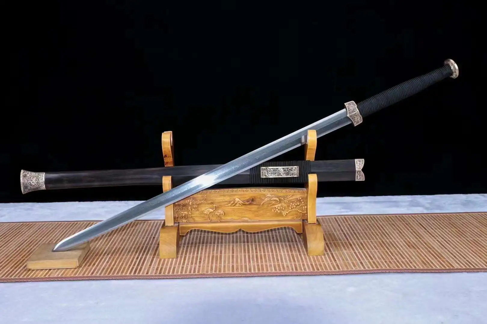 Han Jian A Han Jian sword displayed next to its traditional scabbard, leaning against a small wooden stand.