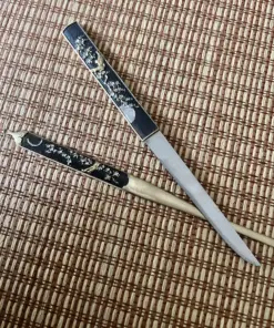 A small Kogatana knife & Kogai traditional Japanese hair pin displayed lying on a bamboo mat.
