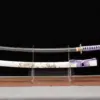 A sword saber Katana displayed next to its scabbard, on a small stand.