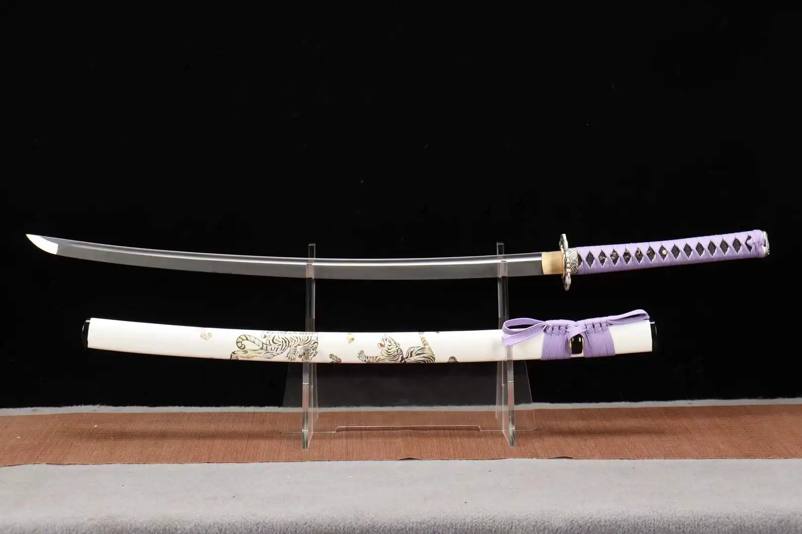 Saber Katana A sword saber Katana displayed next to its scabbard, on a small stand.