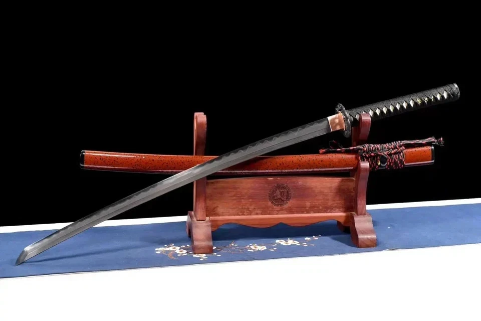 Sharpest Katana A sword made with the sharpest Katana Wootz steel, displayed next to its scabbard, leaning against a small wooden stand.