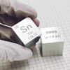 A man's hand holding a science periodic-table pure tin cube block