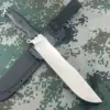 A big survival knife displayed crossed against its scabbard, lying on a camouflage background.