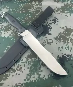 A big survival knife displayed crossed against its scabbard, lying on a camouflage background.