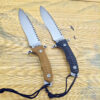 Two bugout knife models with different colored handles displayed on a rattan mat.
