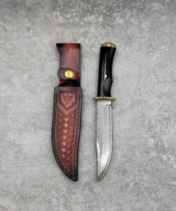 A Damascus hog hunting knife, displayed next to its leather sheath.