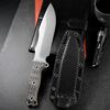An outdoor survival knife displayed next to its sheath.