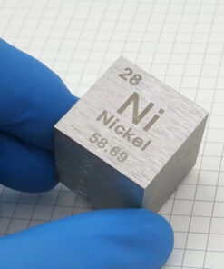 A man's hand wearing a blue glove holding a pure nickel cube block.