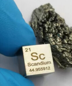 A pure scandium metal cube displayed next to its natural mineral ore.