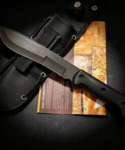 A large survival knife, displayed lying against its sheath.