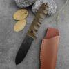 A bushcraft D2 knife, displayed next to a leather knife pouch.